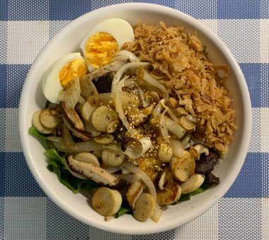 Bibimbap, çeşitli sebzeler, gochujang ve sıklıkla dilimlenmiş etin eşlik ettiği kızarmış yumurta ile süslenmiş canlı bir Kore pirinç yemeği. Karıştırıldığında, aromalı ve dengeli olur..