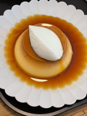 Üstünde zengin karamel soslu yumuşak ve kremalı karamel. Ağızda eriyen bir dokuya ve mükemmel bir tatlılığa sahip. Hoşgörülü ve zarif klasik bir tatlı..