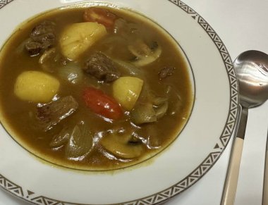 Yumuşak sebzeler ve et parçalarıyla dolu lezzetli bir sosun yer aldığı rahatlatıcı bir Japon köri kasesi yumuşak pirincin üzerine servis edilir. Her yemek için mükemmel, sıcak ve lezzetli bir yemek..