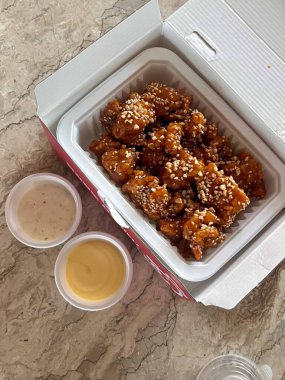 Kızarmış Kore tavuğu, tatlı ve baharatlı sosla mükemmel bir şekilde jölelenmiş. Yemek fotoğrafçılığı ve menüler için idealdir. Bu sevilen yemeğin dayanılmaz çıtırtısını ve lezzetini sergiler..