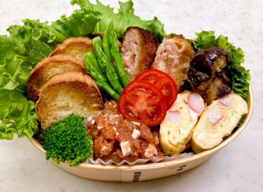 Geleneksel bir Kore dozirak 'ı. Pirinç, çeşitli banchan ve tuzlu proteinlerle güzelce düzenlenmiş. Dengeli ve görsel olarak davetkâr, canlı lezzetlerle dolu taşınabilir bir yemek..