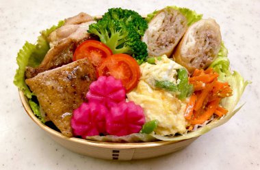 Geleneksel bir Kore dozirak 'ı. Pirinç, çeşitli banchan ve tuzlu proteinlerle güzelce düzenlenmiş. Dengeli ve görsel olarak davetkâr, canlı lezzetlerle dolu taşınabilir bir yemek..