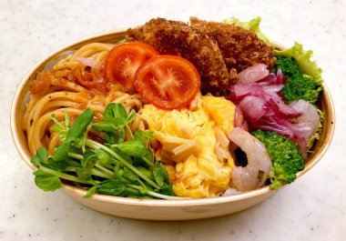 Düzgün düzenlenmiş pirinç, lezzetli protein ve çeşitli mezelerle dolu renkli bir dosirak beslenme çantası. Taşınabilir bir ziyafet, özgün Kore ev usulü yemeklerin özünü yansıtıyor..