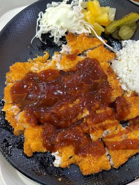 Çıtır tonkatsu, Japon usulü kızarmış domuz pirzolası dilimlenmiş lahana ve tuzlu sosla servis edilir. Lezzetli bir kıtır kıtır doku ve sulu et dengesi.