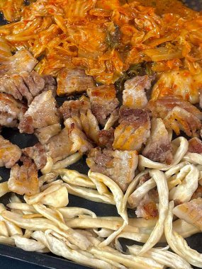 Lezzetli ızgara samgyeopsal, lezzetli mantarlar ve keskin, cızırdayan kimchi ile çiftleştirilmiş, her lezzetli, ağız sulandıran ısırıkta zengin, topraksı ve baharatlı tatların mükemmel bir dengesini yaratıyor..