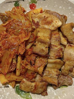 Lezzetli ızgara samgyeopsal, lezzetli mantarlar ve keskin, cızırdayan kimchi ile çiftleştirilmiş, her lezzetli, ağız sulandıran ısırıkta zengin, topraksı ve baharatlı tatların mükemmel bir dengesini yaratıyor..