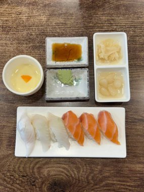 Çiğ balık, pirinç ve yosun gibi canlı malzemelerle güzelce düzenlenmiş taze suşi çeşitleri. Bu zarif Japon yemeği mükemmel bir lezzet ve sunum dengesi sunar..