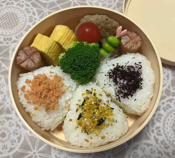 Geleneksel bir Kore dozirak 'ı. Pirinç, çeşitli banchan ve tuzlu proteinlerle güzelce düzenlenmiş. Dengeli ve görsel olarak davetkâr, canlı lezzetlerle dolu taşınabilir bir yemek..