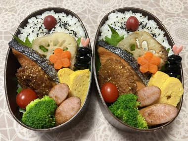 Geleneksel bir Kore dozirak 'ı. Pirinç, çeşitli banchan ve tuzlu proteinlerle güzelce düzenlenmiş. Dengeli ve görsel olarak davetkâr, canlı lezzetlerle dolu taşınabilir bir yemek..