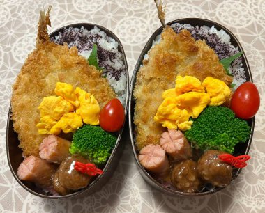 Geleneksel bir Kore dozirak 'ı. Pirinç, çeşitli banchan ve tuzlu proteinlerle güzelce düzenlenmiş. Dengeli ve görsel olarak davetkâr, canlı lezzetlerle dolu taşınabilir bir yemek..