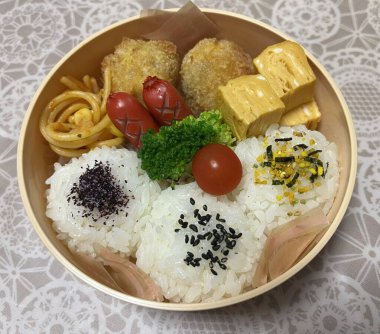 Geleneksel bir Kore dozirak 'ı. Pirinç, çeşitli banchan ve tuzlu proteinlerle güzelce düzenlenmiş. Dengeli ve görsel olarak davetkâr, canlı lezzetlerle dolu taşınabilir bir yemek..