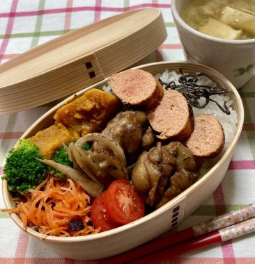 Geleneksel bir Kore dozirak 'ı. Pirinç, çeşitli banchan ve tuzlu proteinlerle güzelce düzenlenmiş. Dengeli ve görsel olarak davetkâr, canlı lezzetlerle dolu taşınabilir bir yemek..