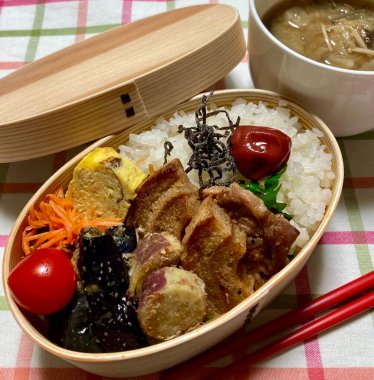 Geleneksel bir Kore dozirak 'ı. Pirinç, çeşitli banchan ve tuzlu proteinlerle güzelce düzenlenmiş. Dengeli ve görsel olarak davetkâr, canlı lezzetlerle dolu taşınabilir bir yemek..