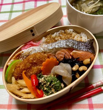 Geleneksel bir Kore dozirak 'ı. Pirinç, çeşitli banchan ve tuzlu proteinlerle güzelce düzenlenmiş. Dengeli ve görsel olarak davetkâr, canlı lezzetlerle dolu taşınabilir bir yemek..