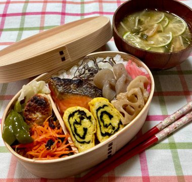 Geleneksel bir Kore dozirak 'ı. Pirinç, çeşitli banchan ve tuzlu proteinlerle güzelce düzenlenmiş. Dengeli ve görsel olarak davetkâr, canlı lezzetlerle dolu taşınabilir bir yemek..