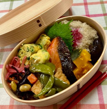 Geleneksel bir Kore dozirak 'ı. Pirinç, çeşitli banchan ve tuzlu proteinlerle güzelce düzenlenmiş. Dengeli ve görsel olarak davetkâr, canlı lezzetlerle dolu taşınabilir bir yemek..