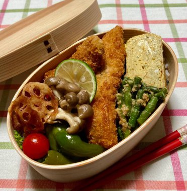 Geleneksel bir Kore dozirak 'ı. Pirinç, çeşitli banchan ve tuzlu proteinlerle güzelce düzenlenmiş. Dengeli ve görsel olarak davetkâr, canlı lezzetlerle dolu taşınabilir bir yemek..