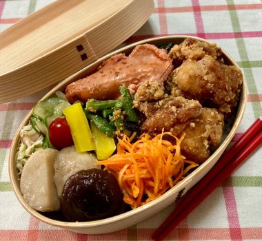 Geleneksel bir Kore dozirak 'ı. Pirinç, çeşitli banchan ve tuzlu proteinlerle güzelce düzenlenmiş. Dengeli ve görsel olarak davetkâr, canlı lezzetlerle dolu taşınabilir bir yemek..