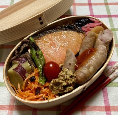 Geleneksel bir Kore dozirak 'ı. Pirinç, çeşitli banchan ve tuzlu proteinlerle güzelce düzenlenmiş. Dengeli ve görsel olarak davetkâr, canlı lezzetlerle dolu taşınabilir bir yemek..