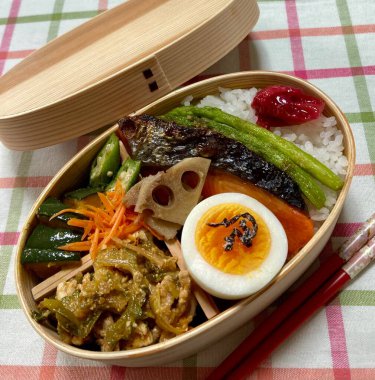 Geleneksel bir Kore dozirak 'ı. Pirinç, çeşitli banchan ve tuzlu proteinlerle güzelce düzenlenmiş. Dengeli ve görsel olarak davetkâr, canlı lezzetlerle dolu taşınabilir bir yemek..