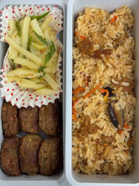 Geleneksel bir Kore dozirak 'ı. Pirinç, çeşitli banchan ve tuzlu proteinlerle güzelce düzenlenmiş. Dengeli ve görsel olarak davetkâr, canlı lezzetlerle dolu taşınabilir bir yemek..