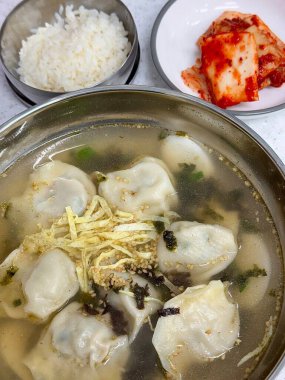 Sıcak, rahatlatıcı bir kase Mandu-guk. Lezzetli bir çorbada köfte bulunan geleneksel Kore çorbası. Kutlamalar sırasında sıklıkla eğlenen bu doyurucu yemek, zengin lezzet ve dokularla doludur..