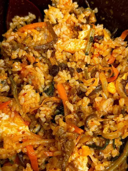 Bibimbap, çeşitli sebzeler, gochujang ve sıklıkla dilimlenmiş etin eşlik ettiği kızarmış yumurta ile süslenmiş canlı bir Kore pirinç yemeği. Karıştırıldığında, aromalı ve dengeli olur..
