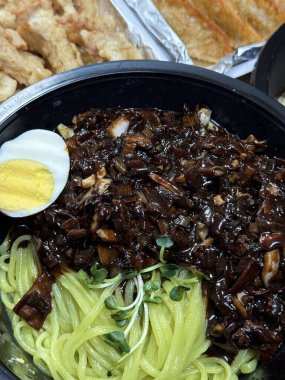 Bir kase jajangmyeon, üzerinde bol siyah fasulye soslu, doğranmış domuz eti ve sebzeler bulunan çiğnenmiş erişteler. Bu ikonik Kore-Çin yemeği lezzetli ve sağlıklı bir lezzet sunuyor..