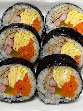 Taze sebzelerle, baharatlı pirinçlerle ve gevrek yosunlara sarılmış lezzetli proteinlerle dolu nefis kimbap dürümleri. Her ısırıkta lezzet ve dokuların mükemmel bir kombinasyonu.