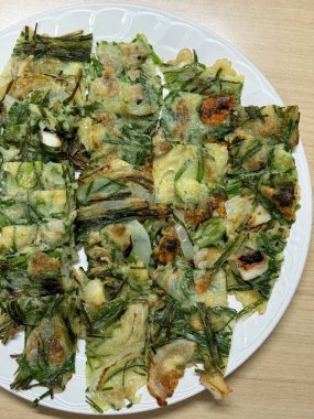 Kıtır kıtır ve lezzetli Kore Pajeon 'u ya da yeşil soğan ve çeşitli sebzelerle yapılan soğanlı krep. Lezzetli, geleneksel bir Kore yemeği. Her yemek için mükemmel..