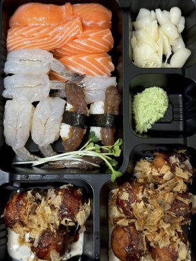 Çeşitli malzemeler ve canlı renklerle sanatsal olarak düzenlenmiş taze suşi çeşitleri. Bu geleneksel Japon yemeği bir deneyim için sirkeli pirinç, deniz ürünleri ve sebzeleri birleştirir..