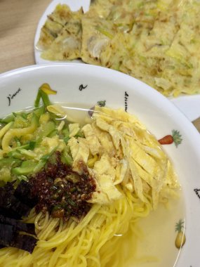 Janchi Guksu, hafif ve lezzetli Kore eriştesi çorbası, sebze, yumurta şeritleri ve deniz yosunlarıyla kaplı. Basit ama lezzetli bir yemek genellikle özel durumlarda yenir..