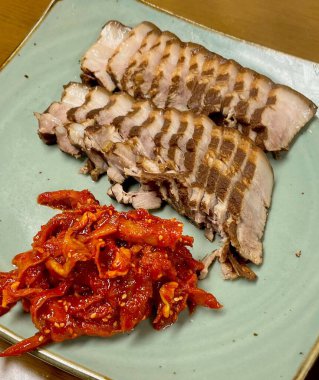 Yumuşak bir parça Bossam, Kore haşlanmış domuz göbeği, taze marul, sarımsak ve ssamjang ile servis edilir. Bu lezzetli ve lezzetli yemek geleneksel bir Kore yemeğini paketlemek ve paylaşmak için mükemmeldir..