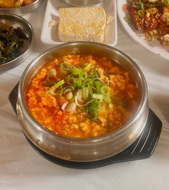 Masada kimçi, turşu sebze turşusu ve baharatlı sebzeler gibi çeşitli banchan (yan yemekler) içeren canlı bir Kore yemeği serpintisi. Yemek fotoğrafçılığı için mükemmel, geleneksel Korece sergileniyor..