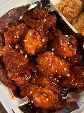 Kızarmış Kore tavuğu, tatlı ve baharatlı sosla mükemmel bir şekilde jölelenmiş. Yemek fotoğrafçılığı ve menüler için idealdir. Bu sevilen yemeğin dayanılmaz çıtırtısını ve lezzetini sergiler..