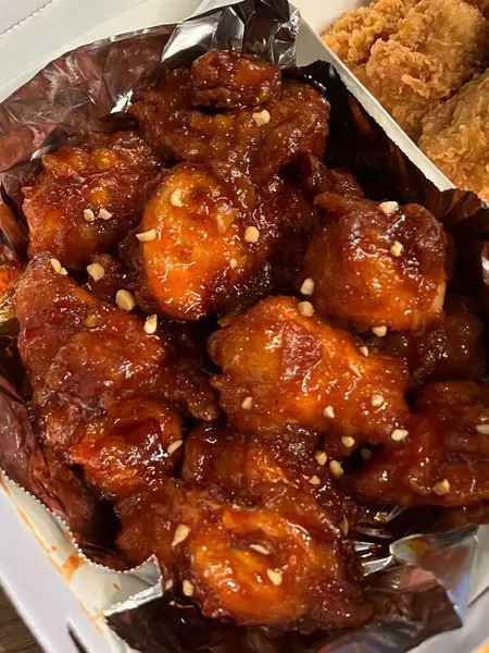 Kızarmış Kore tavuğu, tatlı ve baharatlı sosla mükemmel bir şekilde jölelenmiş. Yemek fotoğrafçılığı ve menüler için idealdir. Bu sevilen yemeğin dayanılmaz çıtırtısını ve lezzetini sergiler..