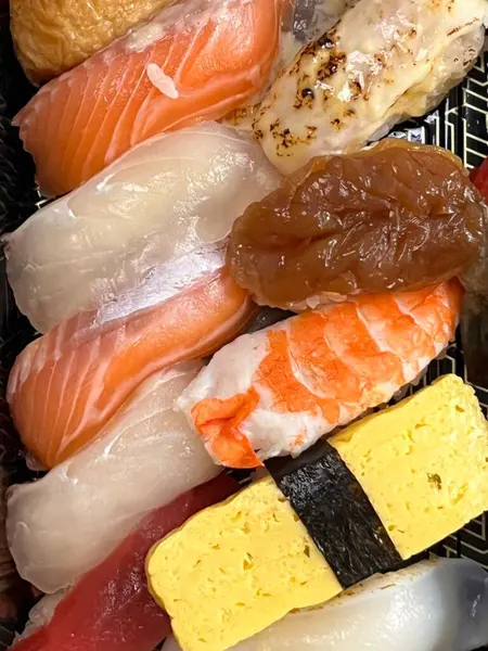 Çeşitli malzemeler ve canlı renklerle sanatsal olarak düzenlenmiş taze suşi çeşitleri. Bu geleneksel Japon yemeği bir deneyim için sirkeli pirinç, deniz ürünleri ve sebzeleri birleştirir..