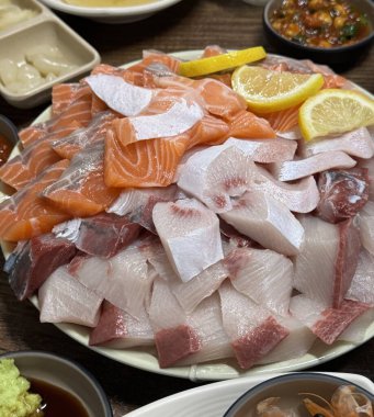 Taze ve narin sashimi dilimleri, canlı renkler ve mükemmel kesimlerle güzelce sunuluyor. Bu geleneksel Japon lezzeti kaliteli deniz ürünlerinin saf tatlarını vurgular..