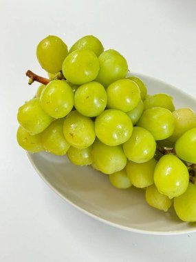 Taze Shine Muscat üzümleri, taze dokuları ve tatlı ve ferahlatıcı tadı ile bilinir. Özel meyve, yemek fotoğrafçılığı, sağlıklı beslenme kavramları ve gurme projeleri için ideal..