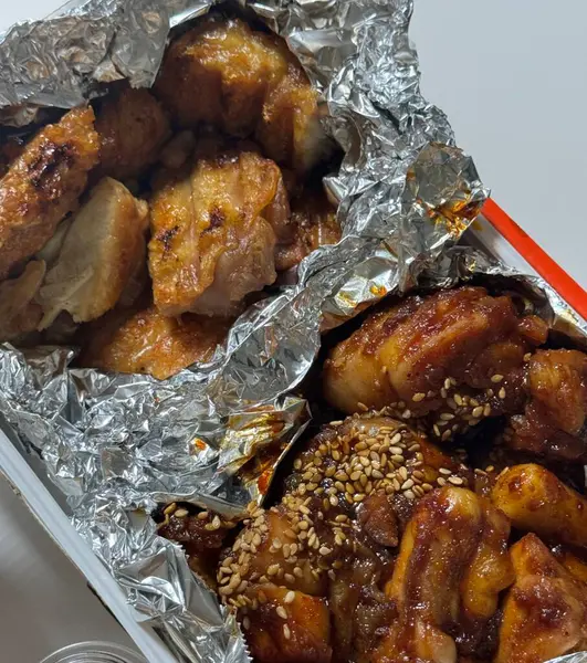 Kızarmış Kore tavuğu, tatlı ve baharatlı sosla mükemmel bir şekilde jölelenmiş. Yemek fotoğrafçılığı ve menüler için idealdir. Bu sevilen yemeğin dayanılmaz çıtırtısını ve lezzetini sergiler..