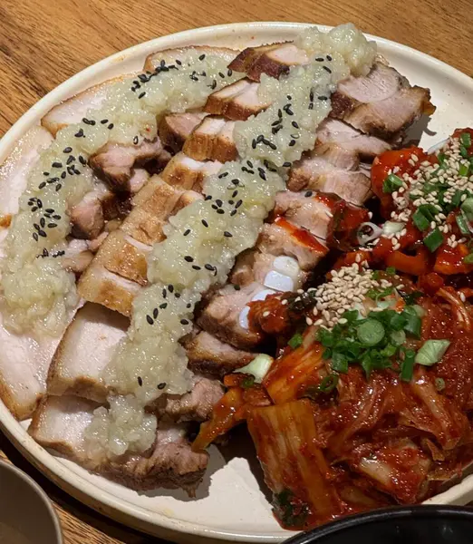 Yumuşak bir parça Bossam, Kore haşlanmış domuz göbeği, taze marul, sarımsak ve ssamjang ile servis edilir. Bu lezzetli ve lezzetli yemek geleneksel bir Kore yemeğini paketlemek ve paylaşmak için mükemmeldir..