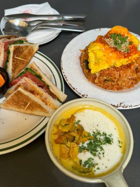 Hoş bir kafe ortamında sergilenen tatlı çeşitleri zarif tabaklar üzerinde pastalar, pastalar ve tatlı ikramlar, sıcak ve davetkar bir atmosfer yaratıyor..