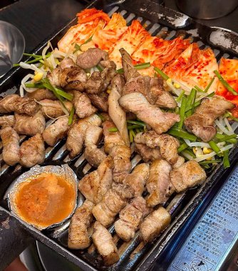Sulu ızgara samgyeopsal baharatlı, keskin kimchi ile eşleştirilmiş, her cızırtılı, ağız sulandıran ısırıkta zengin, lezzetli etten ve fermente edilmiş cesur bir armoni sunuyor..
