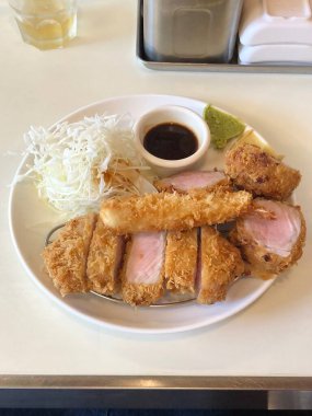 Çıtır tonkatsu, Japon usulü kızarmış domuz pirzolası dilimlenmiş lahana ve tuzlu sosla servis edilir. Lezzetli bir kıtır kıtır doku ve sulu et dengesi.