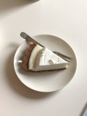 Lezzetli bir dilim peynirli kek, kremalı, pürüzsüz dokulu ve altın bisküvi kabuklu. Tatlılar, kutlamalar ve tatlı ikramları için mükemmel. Zengin, hoşgörülü ve karşı konulmaz derecede lezzetli.!