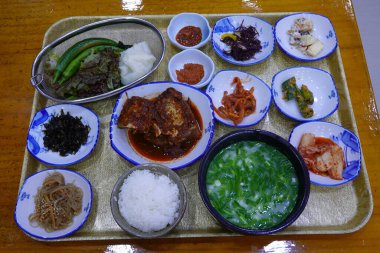 Masada kimçi, turşu sebze turşusu ve baharatlı sebzeler gibi çeşitli banchan (yan yemekler) içeren canlı bir Kore yemeği serpintisi. Yemek fotoğrafçılığı için mükemmel, geleneksel Korece sergileniyor..