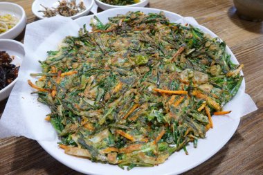 Kıtır kıtır ve lezzetli Kore Pajeon 'u ya da yeşil soğan ve çeşitli sebzelerle yapılan soğanlı krep. Lezzetli, geleneksel bir Kore yemeği. Her yemek için mükemmel..
