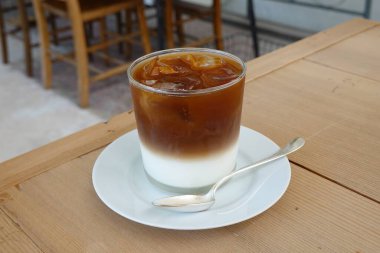 Çok güzel işlenmiş bir latte, kremalı köpüklü sanat eseri ve üstüne de espresso. Kahveyle ilgili projeler için mükemmel. Bu görüntü, klasik bir kafe deneyiminin sıcaklığını ve davetkar doğasını yansıtıyor..