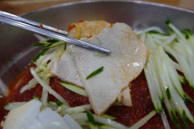 Soğukta çiğnenmiş karabuğday erişteli otantik Pyongyang naengmyeonu taze ve lezzetli bir tat sunuyor. Geleneksel Kore mutfak menüleri ve yaz yemekleri için mükemmel..