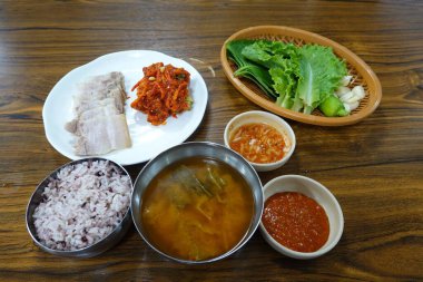 Masada kimçi, turşu sebze turşusu ve baharatlı sebzeler gibi çeşitli banchan (yan yemekler) içeren canlı bir Kore yemeği serpintisi. Yemek fotoğrafçılığı için mükemmel, geleneksel Korece sergileniyor..
